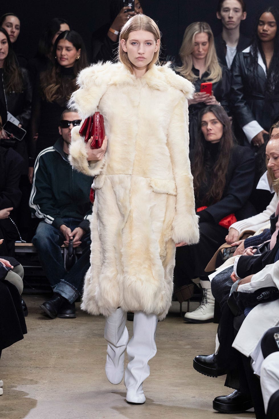 Model showcasing a stylish fur coat during a fashion show